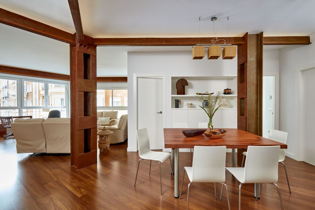 Salón-comedor de la Casa en El Alba con estructura metálica vista y acabado oxidado · Arquitectura Nítida