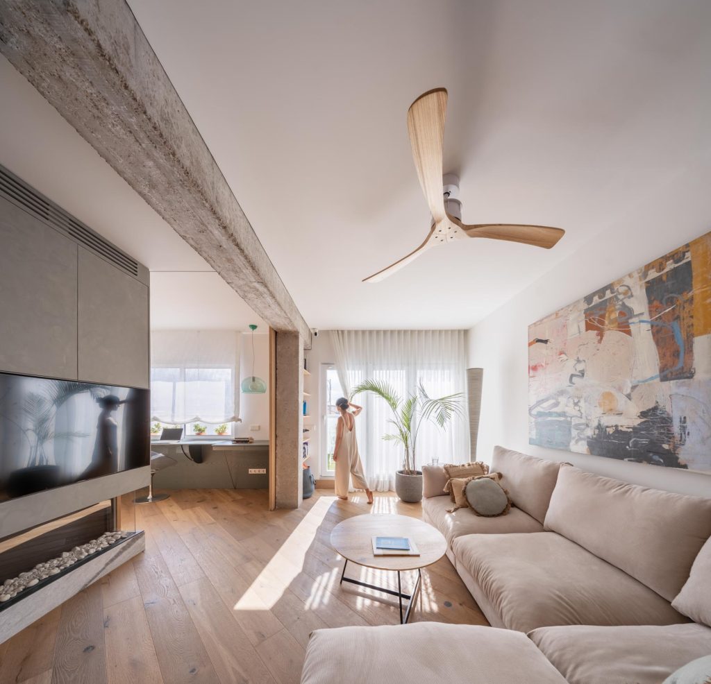 Interior del Ático de hormigón y madera reformado por Nítida arquitectos en Murcia, con viga de hormigón visto, pavimento de roble y espacio diáfano abierto a terraza
