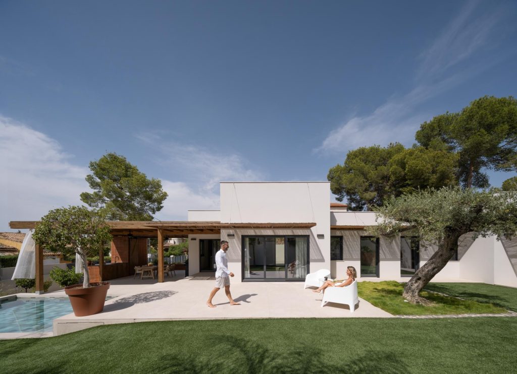 Pareja disfrutando de la piscina exterior de Casa Acacias, vivienda de estilo ibicenco · Arquitectura Nítida