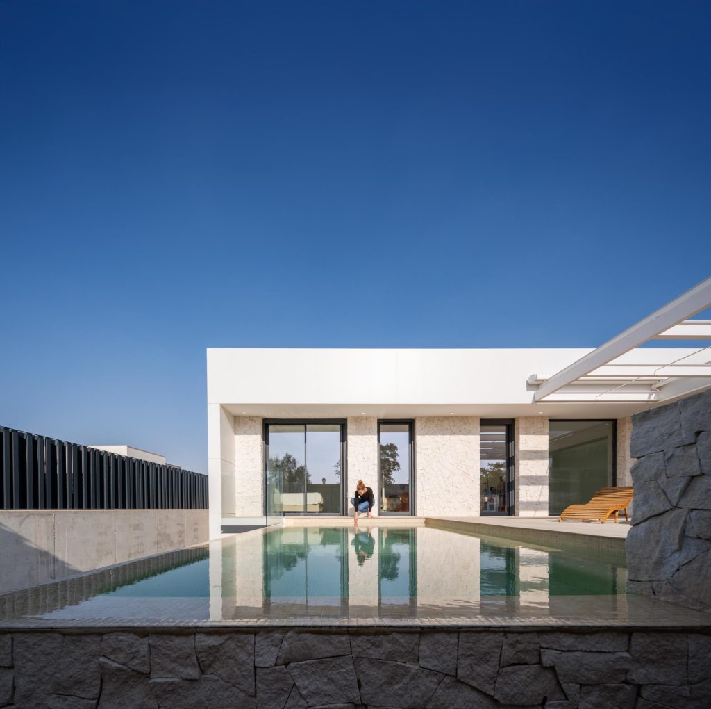 Vista de piscina en el exterior de Casa Poniente, vivienda unifamiliar · Arquitectura Nítida