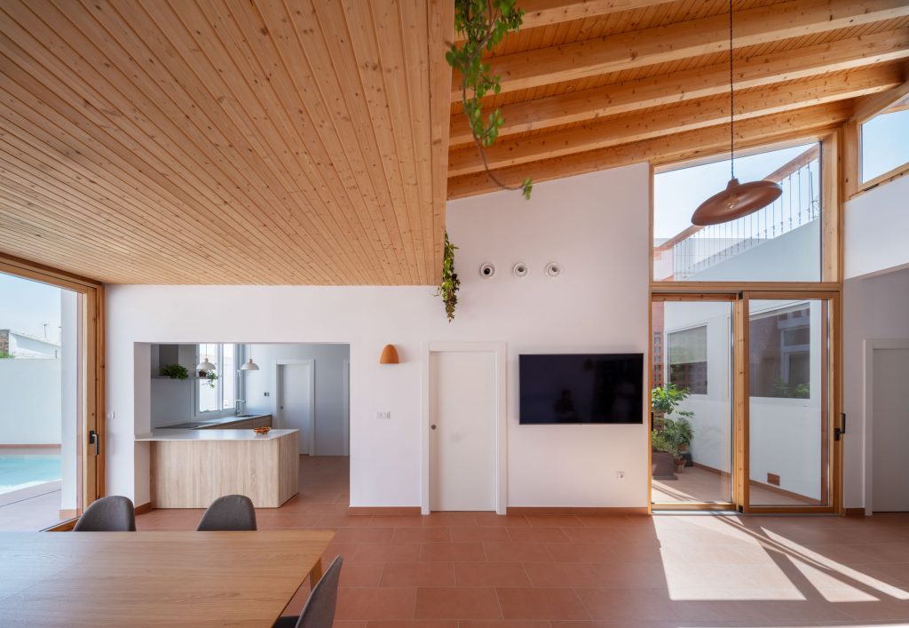 Interior luminoso de Casa tras Celosías, con cocina-comedor abierto al exterior filtrado por celosías · Arquitectura Nítida